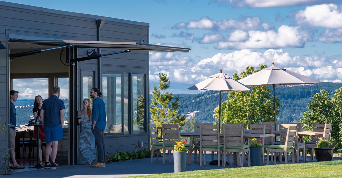 Guests at Fairsing Vineyard gather on patio to enjoy estate Pinot noir and panoramic views of Oregon's Willamette Valley