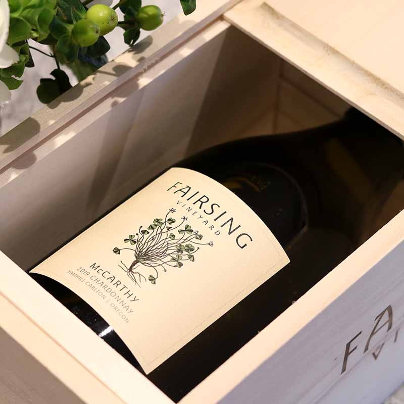 A magnum of spring release Fairsing Vineyard McCarthy Chardonnay in a wooden box near flowers at the tasting room in Oregon's Willamette Valley