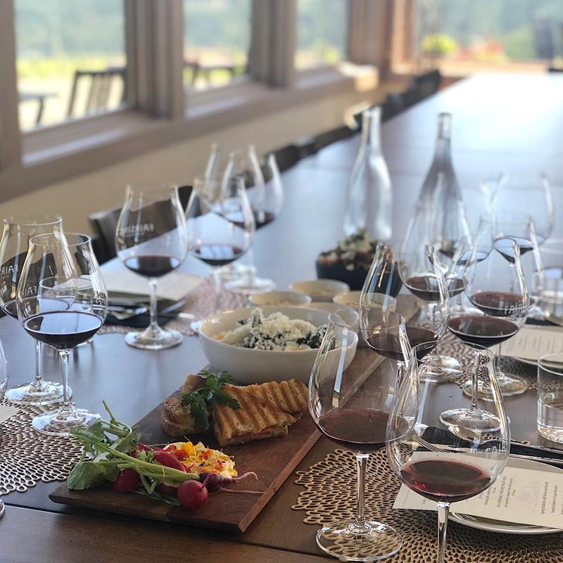 A luncheon with glasses of Fairsing Vineyard Pinot noir await Guests in the semi-private event venue