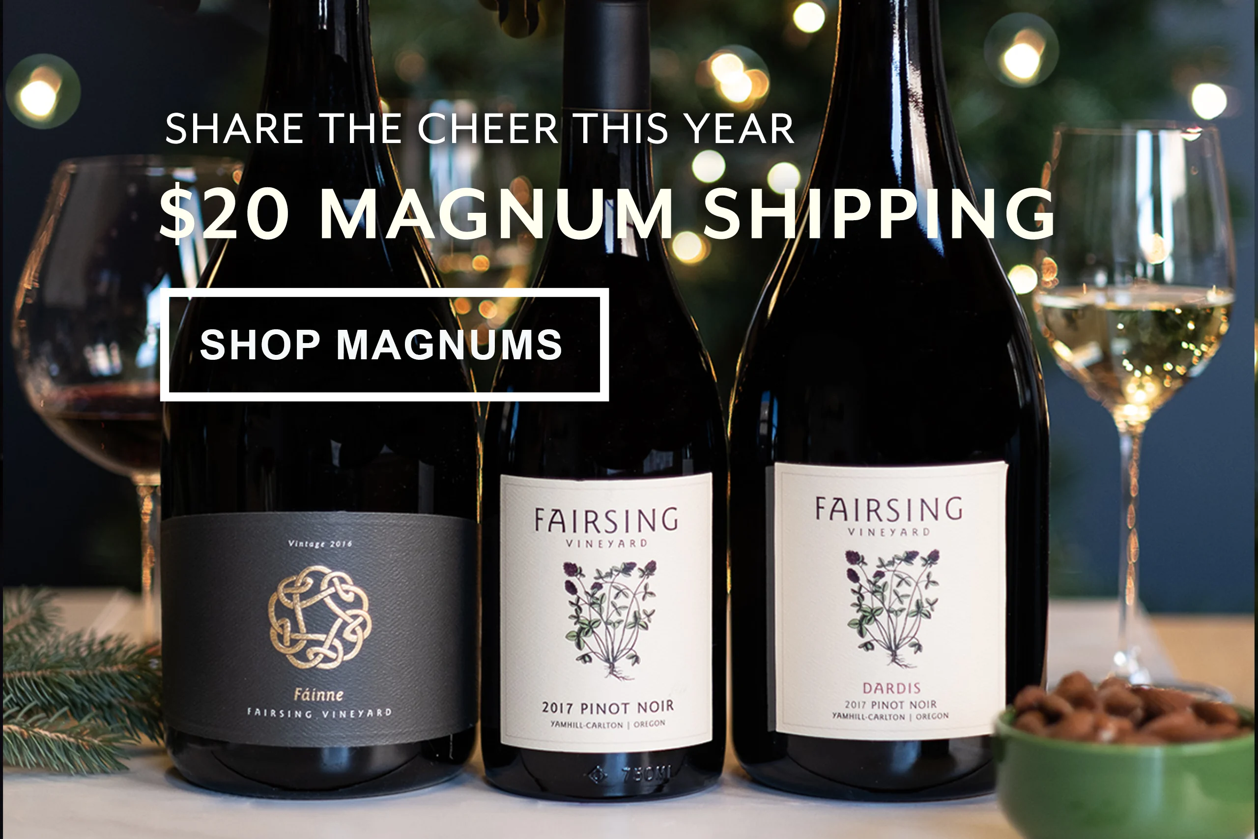 Two magnums and one bottle of Fairsing Vineyard estate wines with crimson clover and a Celtic Knot on the label surrounded by greenery, lights, and wine glasses for the holiday season